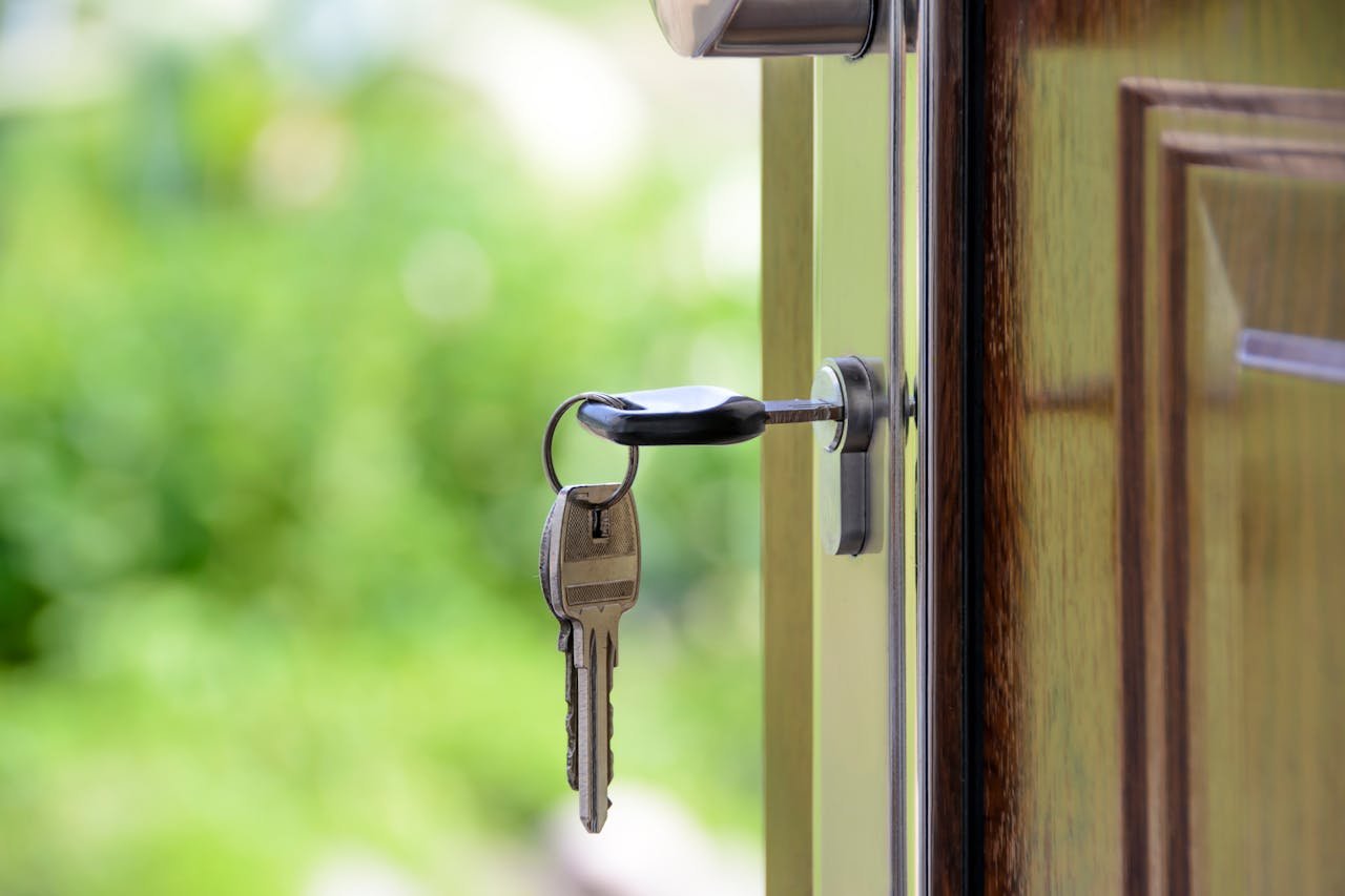 The Art of Drawing Readers In: Your attractive post title goes here Key inserted in door lock against a blurred green background, symbolizing security and real estate.
